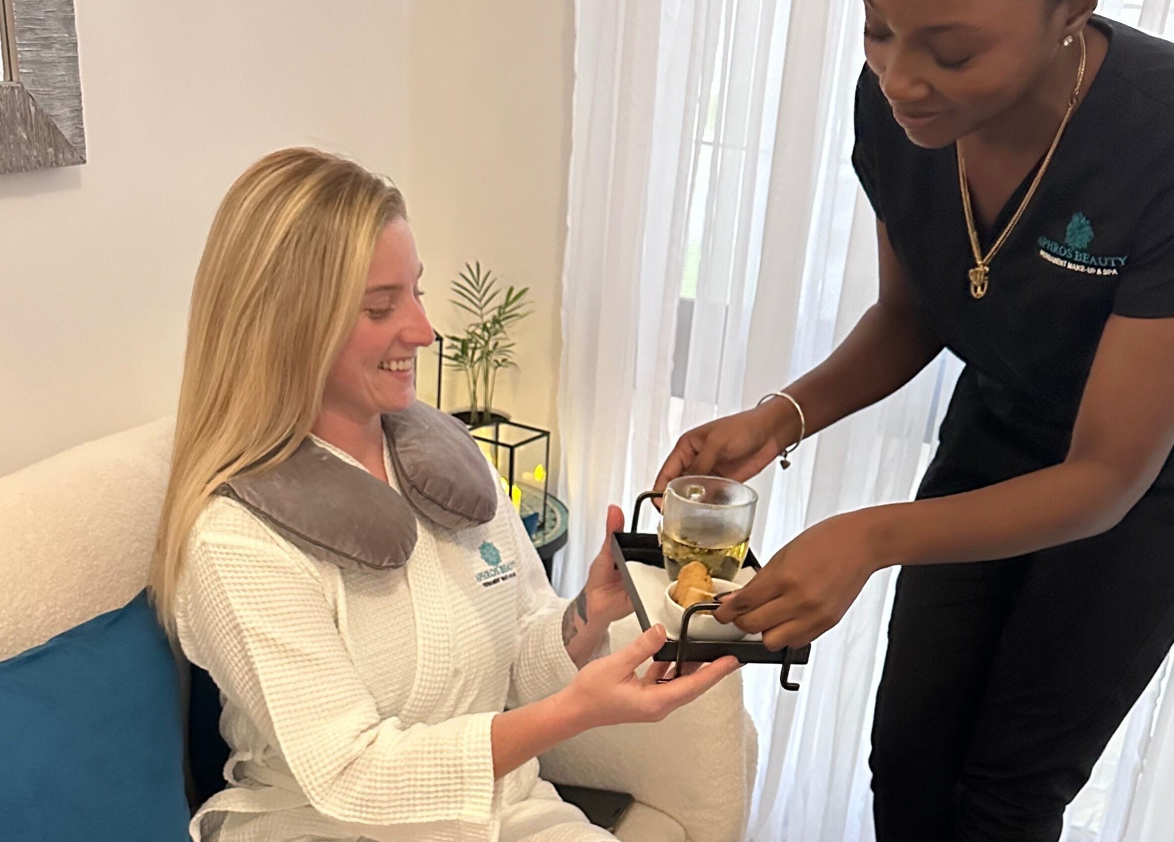 Aphros Beauty therapist serves tea to a client in a cozy room in Homewood, Alabama, US.