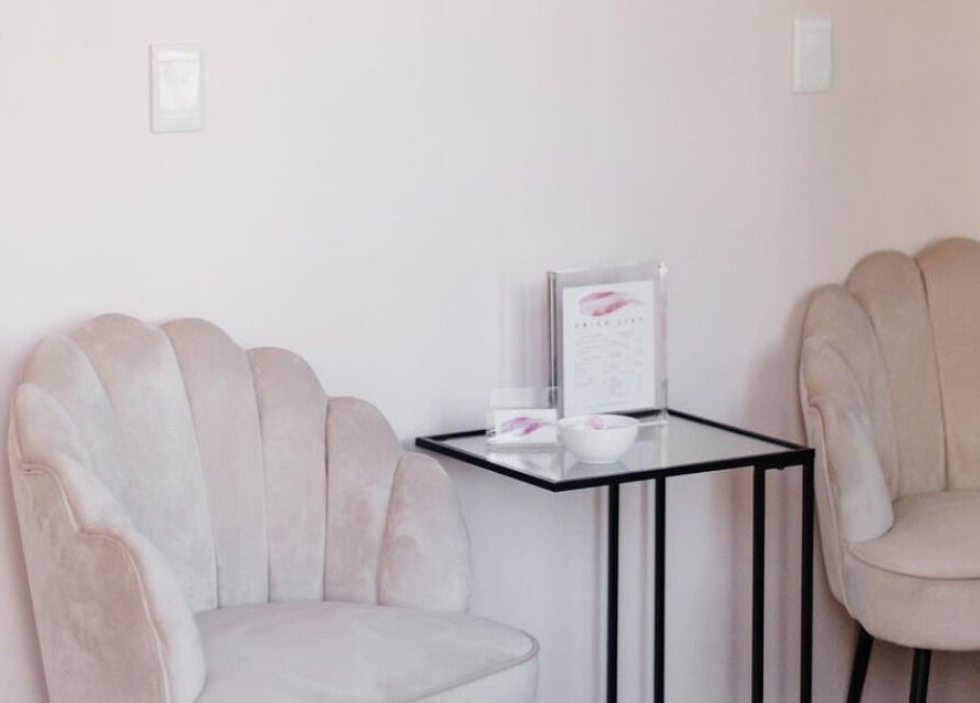 Elegant seating area at The Brow Specialist, Somerset West, Western Cape, ZA with plush chairs and side table.