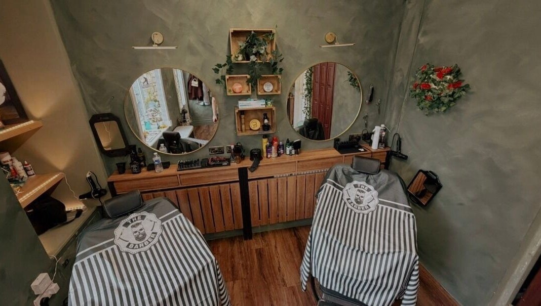 Elegant barbershop setup at The LadyBarber’s Shop in New Bradwell, England, GB with stylish mirrors and chairs.