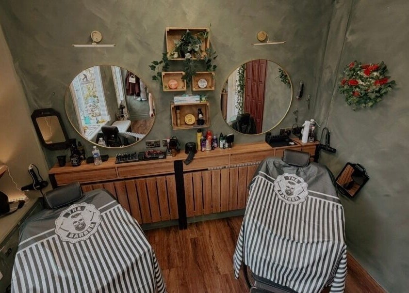 Elegant barbershop setup at The LadyBarber’s Shop in New Bradwell, England, GB with stylish mirrors and chairs.