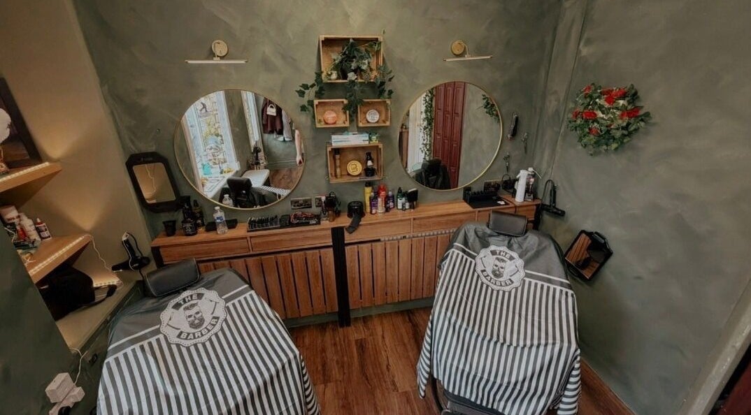 Elegant barbershop setup at The LadyBarber’s Shop in New Bradwell, England, GB with stylish mirrors and chairs.