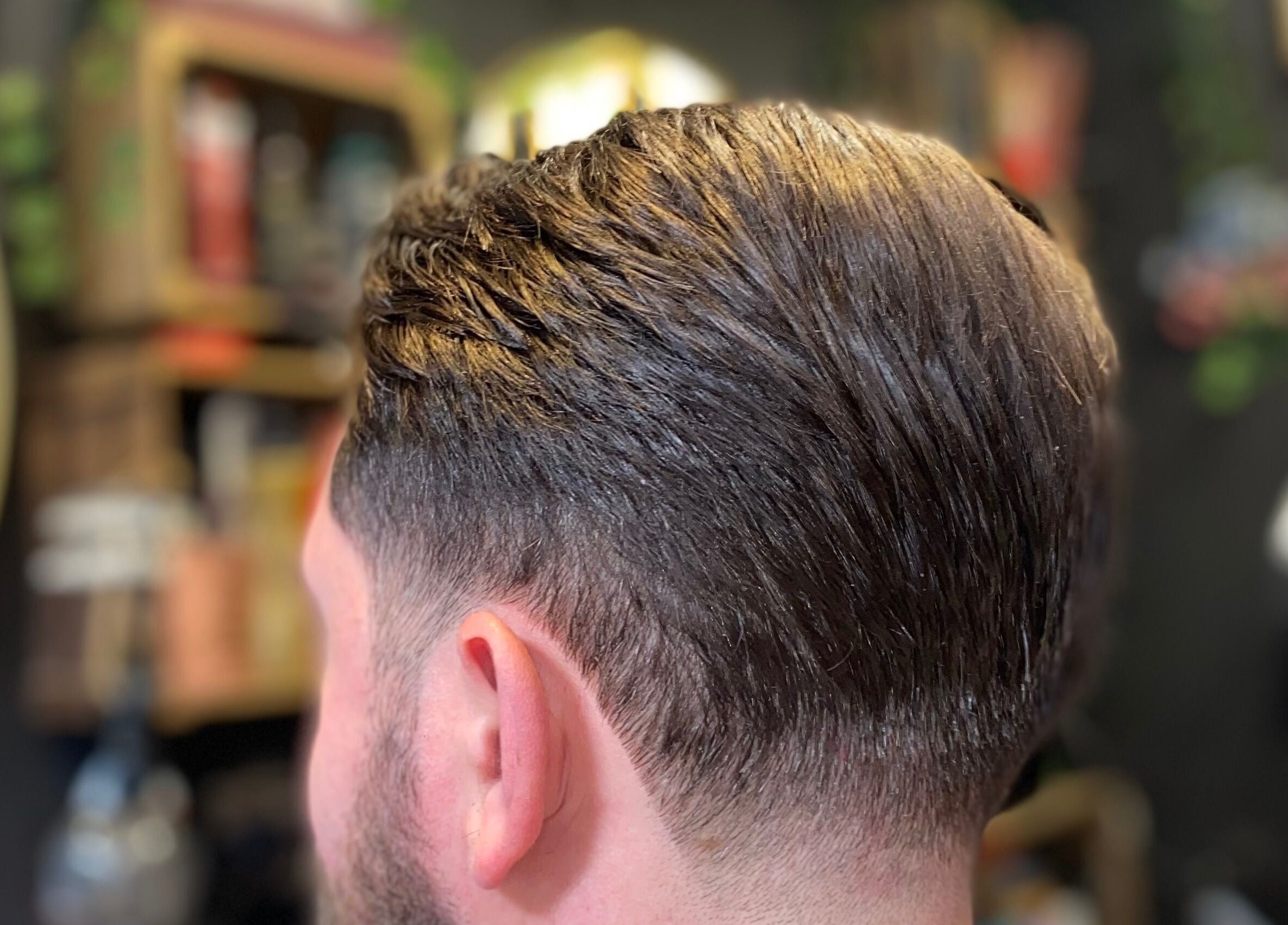 Sleek men's haircut at The LadyBarber’s Shop in New Bradwell, England, GB, showcasing expert styling.
