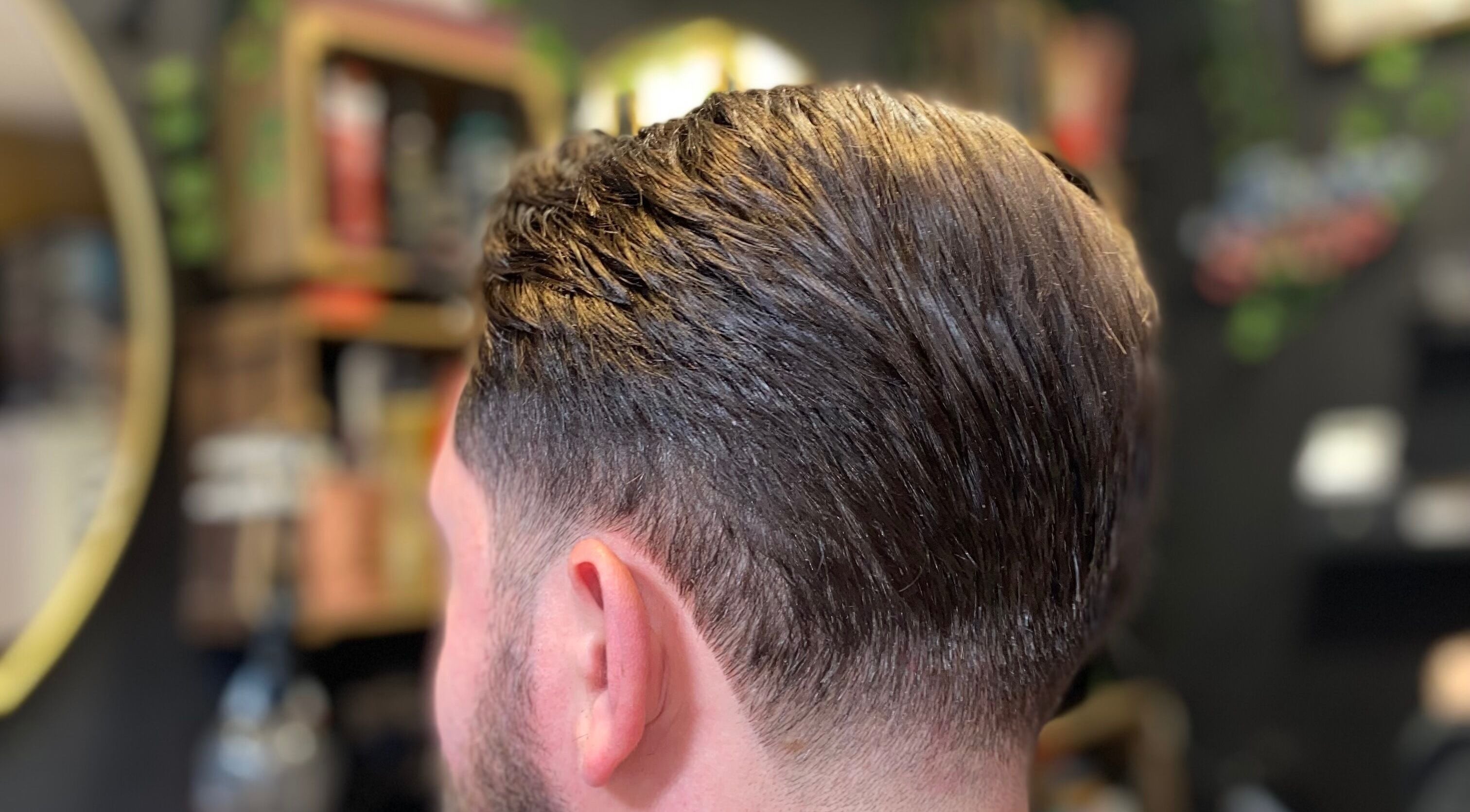 Sleek men's haircut at The LadyBarber’s Shop in New Bradwell, England, GB, showcasing expert styling.