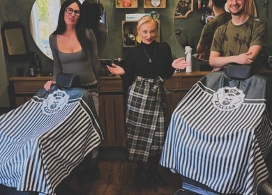 Staff at The LadyBarber’s Shop in New Bradwell, England, GB, showcase stylish interior with barber chairs.