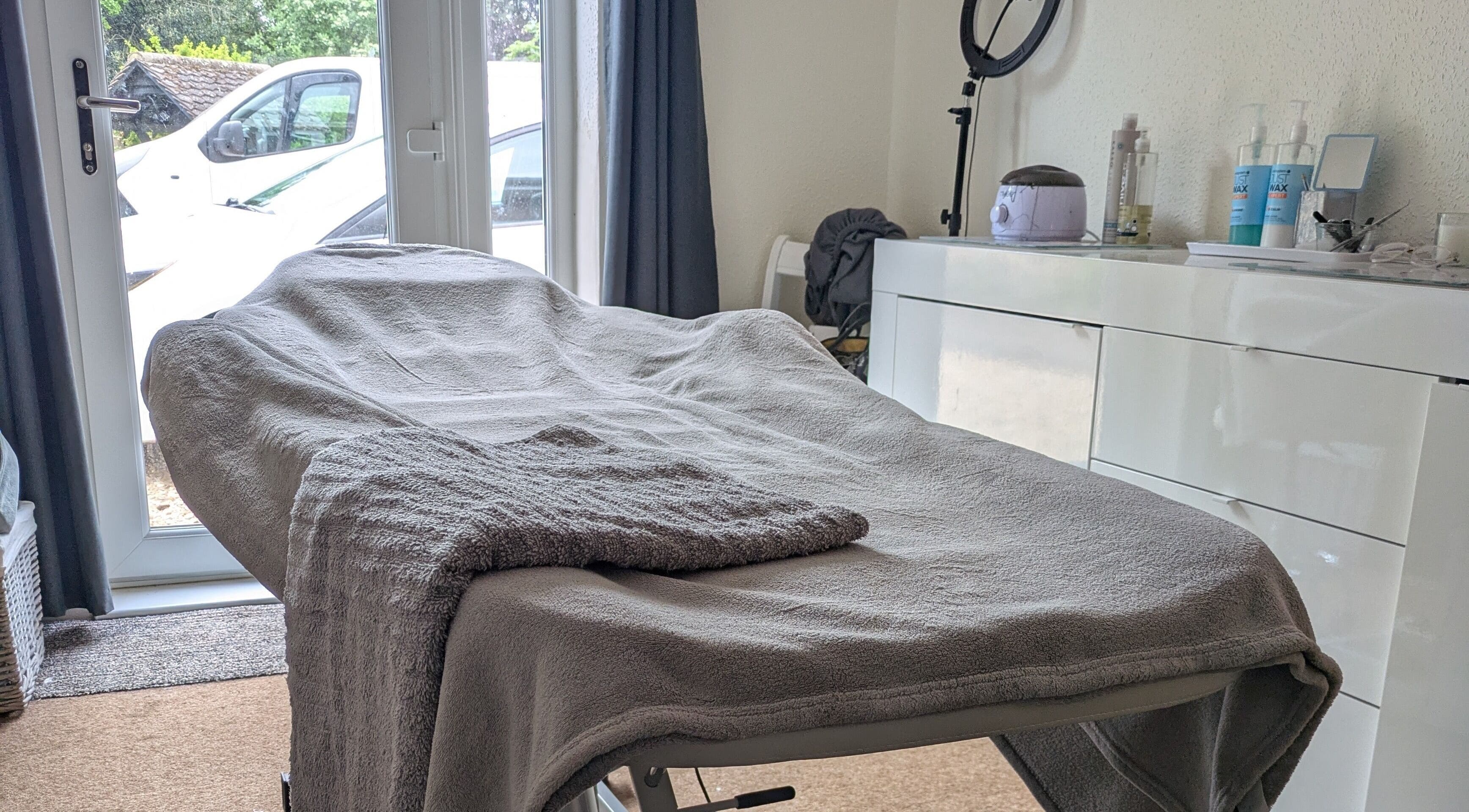 Relaxing treatment room at Beauty by Bex in March, England, GB, with cozy massage bed and calming decor.