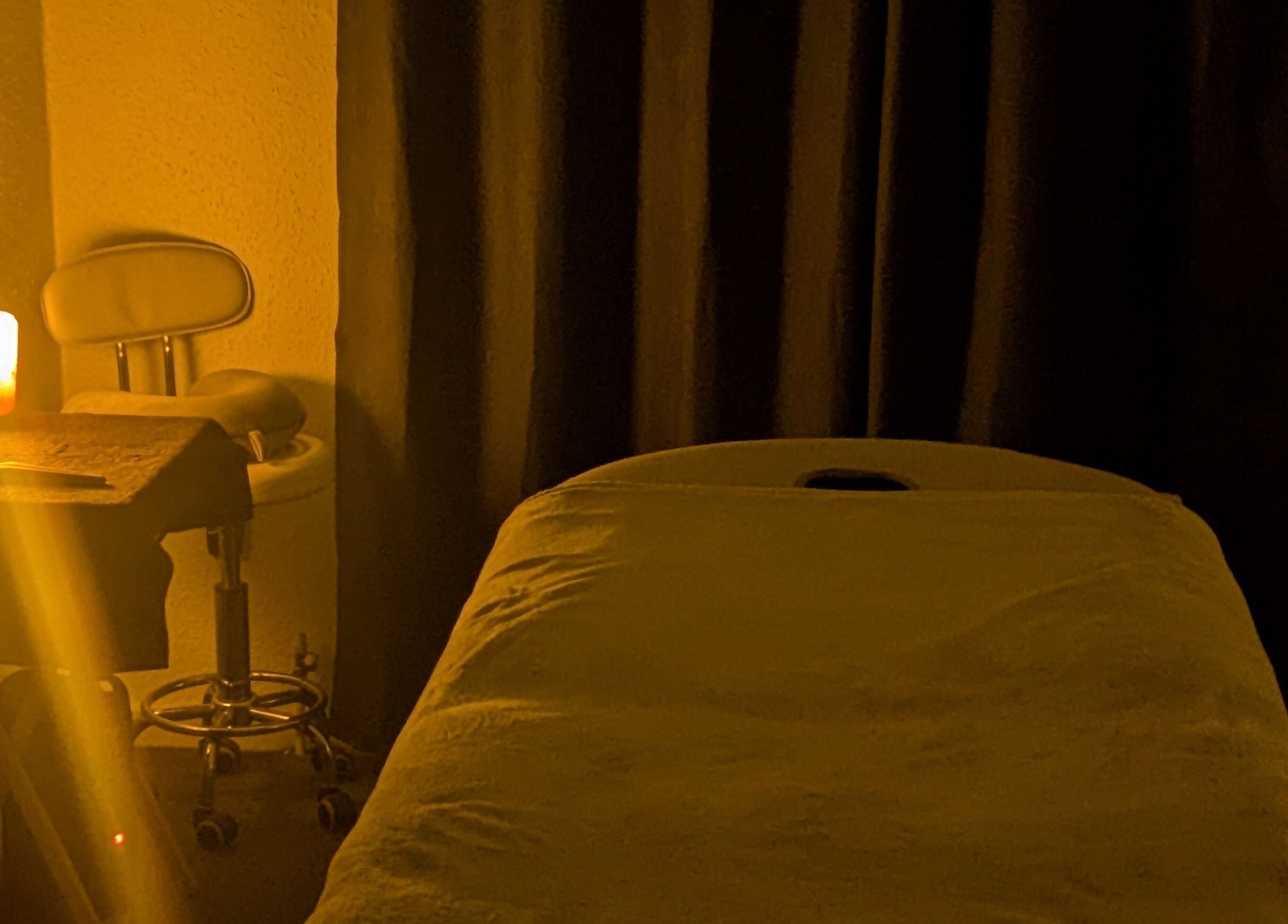 Cozy massage room at Beauty by Bex Treatment Room, March, England, GB, with warm lighting and a therapy bed.