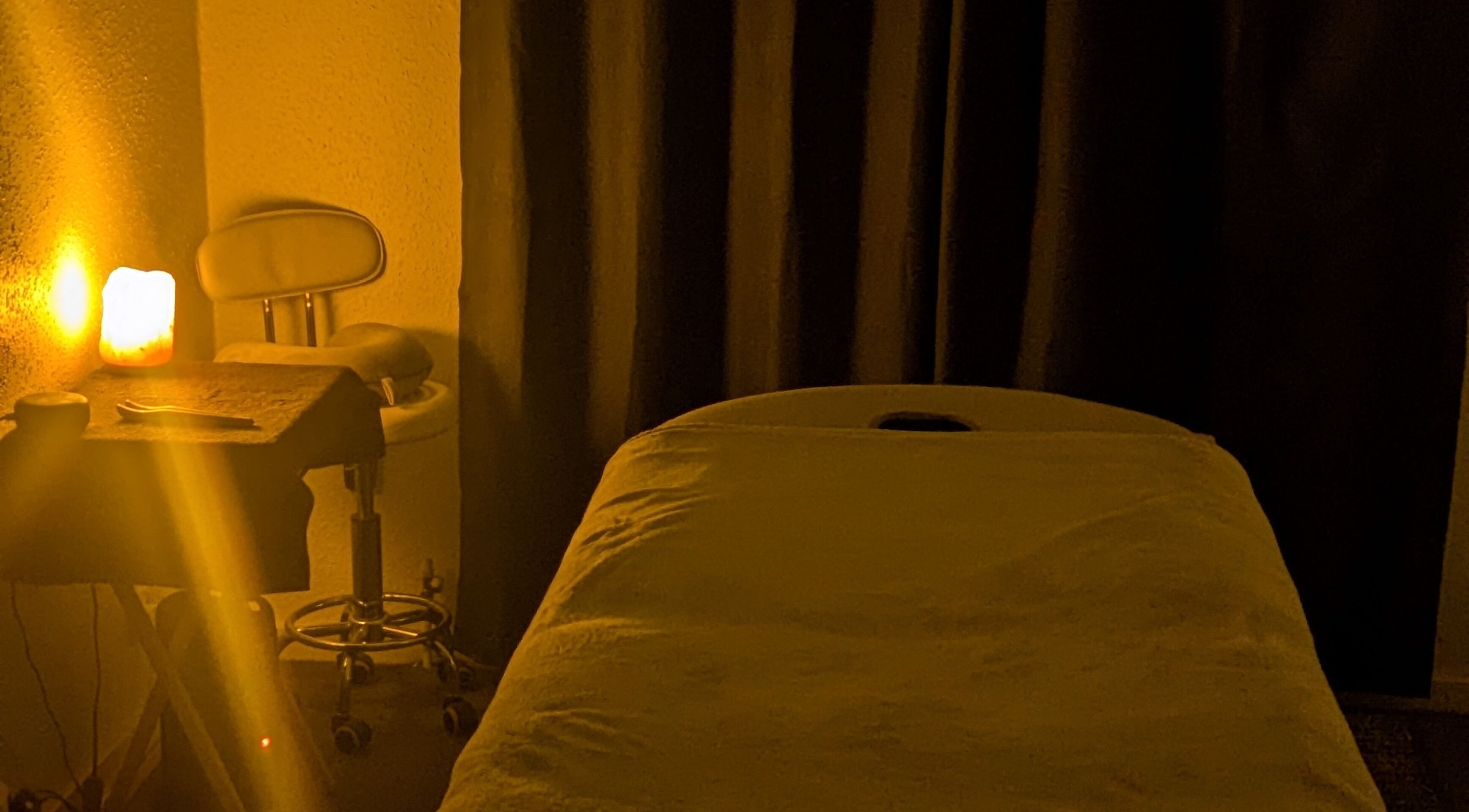 Cozy massage room at Beauty by Bex Treatment Room, March, England, GB, with warm lighting and a therapy bed.