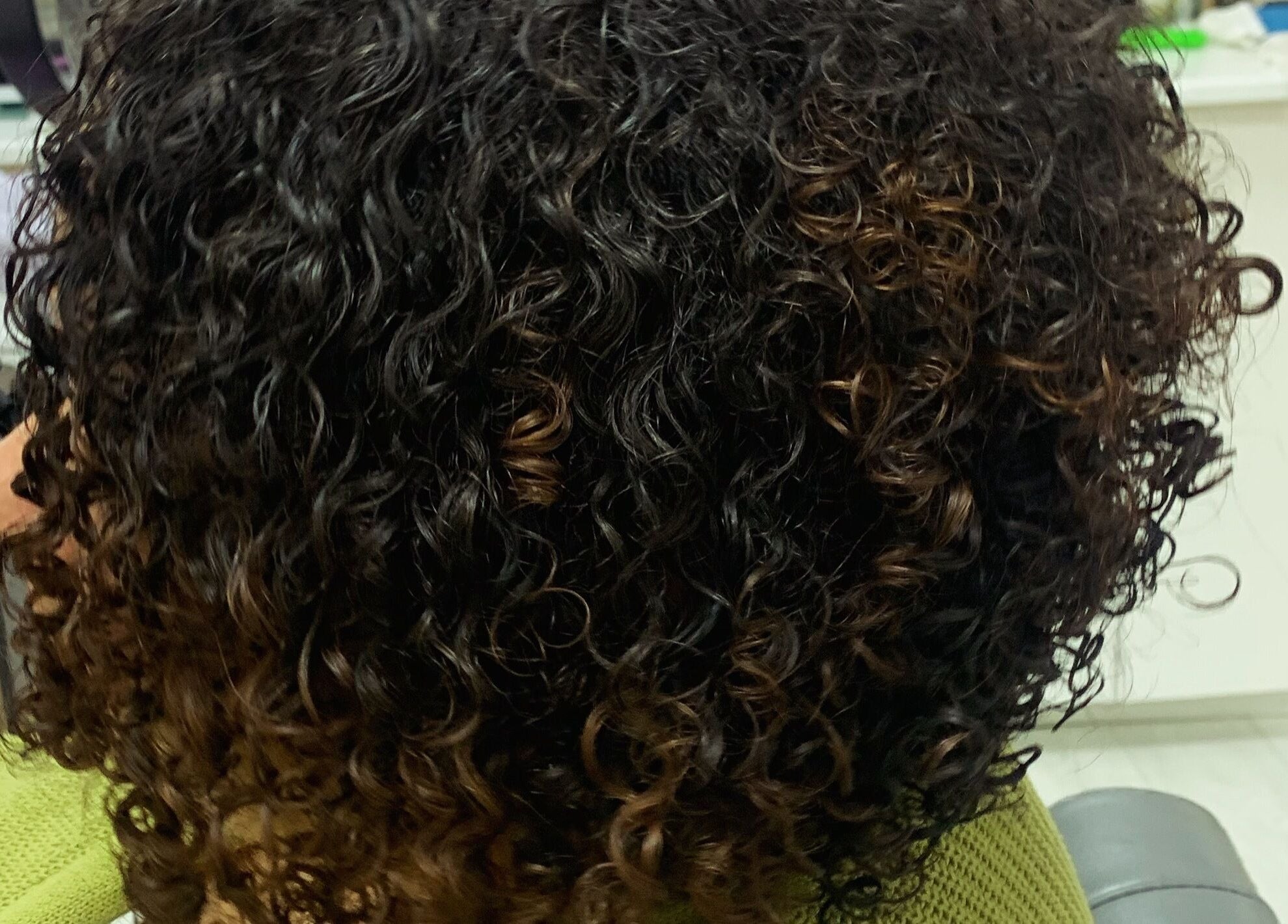 Lustrous curly hairstyle at Manes by Morgan, Willenhall, England, GB, highlighting deep black and brown tones.