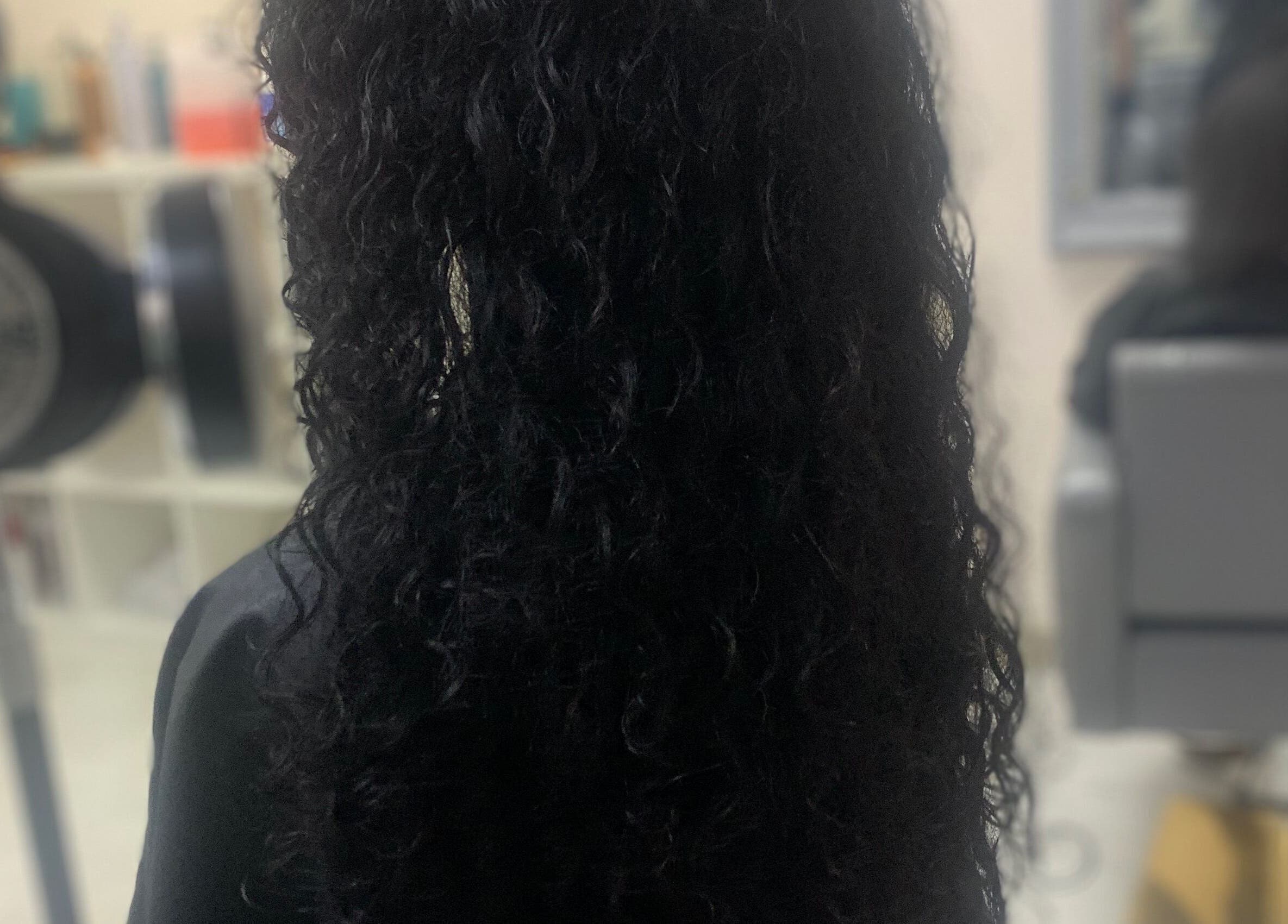 Curly hairstyle at Manes by Morgan in Willenhall, England, GB. Sleek salon look.