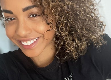 Smiling woman with curly hair at Manes by Morgan, Birmingham, England, GB.