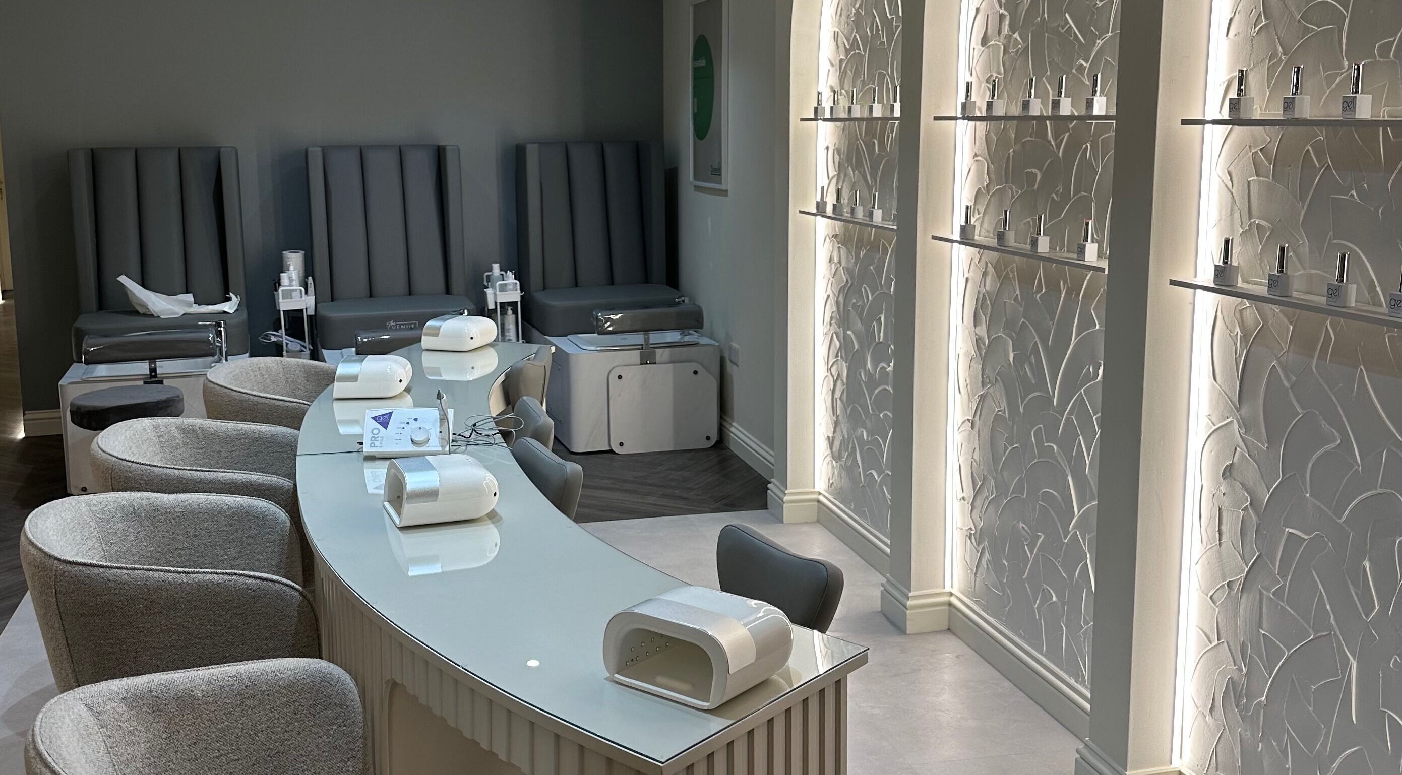 Manicure stations at The Venue Clinic Christchurch, featuring plush seating and modern decor. Located in Christchurch, GB.