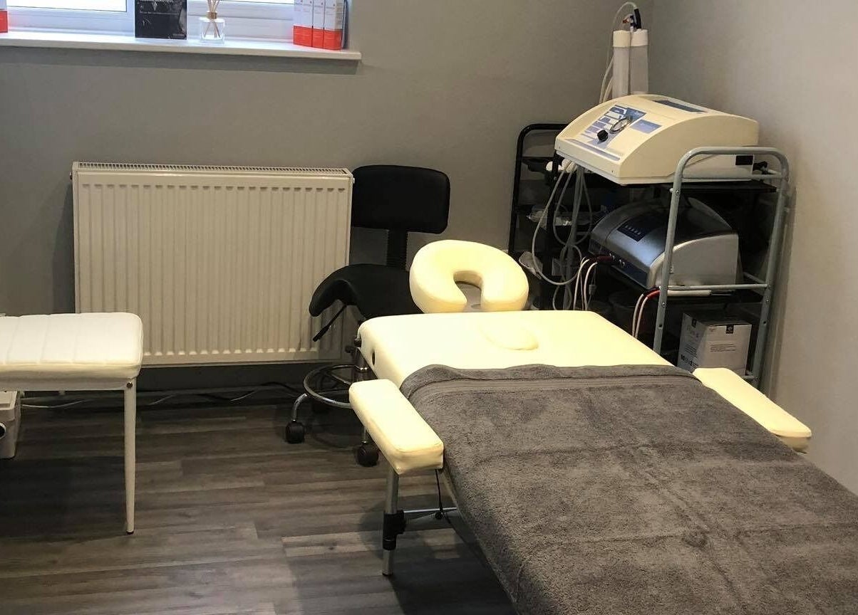 Treatment room at Revive Laser Clinic in Snodland, England, GB, featuring a massage table and equipment.