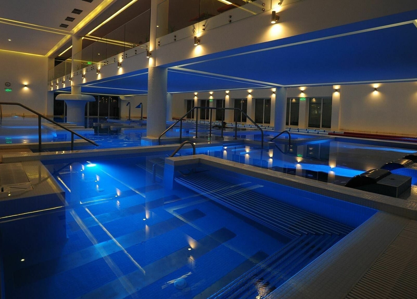 Elegant indoor pools at Aqvatonic Balneo Spa, Eforie Nord, Județul Constanța, RO, illuminated with soft blue lights.
