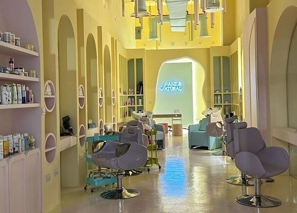 Modern salon interior at ManeandNatural | كيرلي بوتيك - Riyadh Branch, Riyadh, SA, with stylish chairs and shelves.