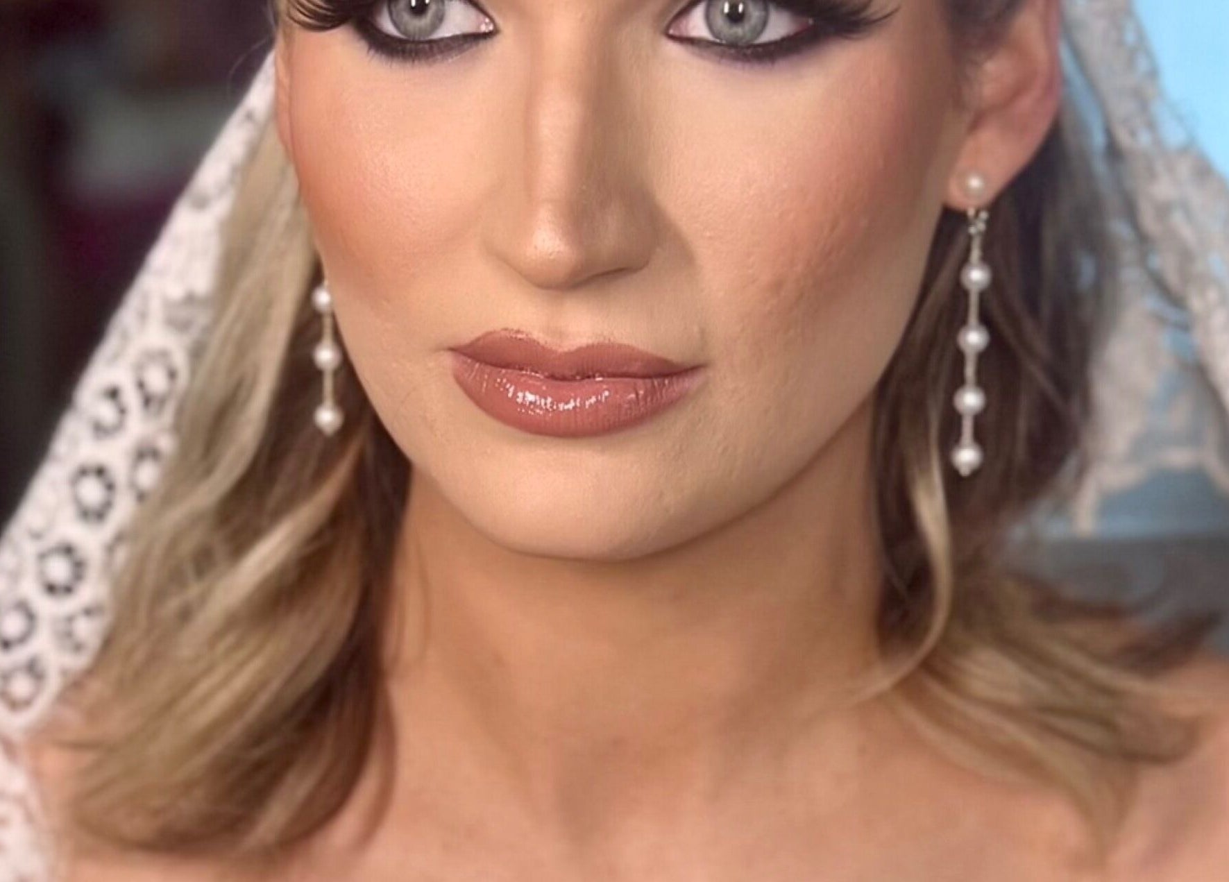 Bridal makeup at Pink Mantis Beauty in Nashville, Tennessee with pearl earrings and lace details.