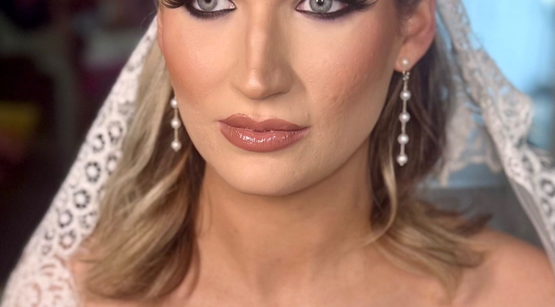 Bridal makeup at Pink Mantis Beauty in Nashville, Tennessee with pearl earrings and lace details.