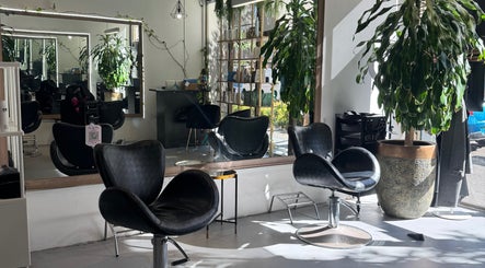 Modern salon interior at Hair by Florie, Surry Hills, New South Wales, AU, featuring stylish chairs and greenery.