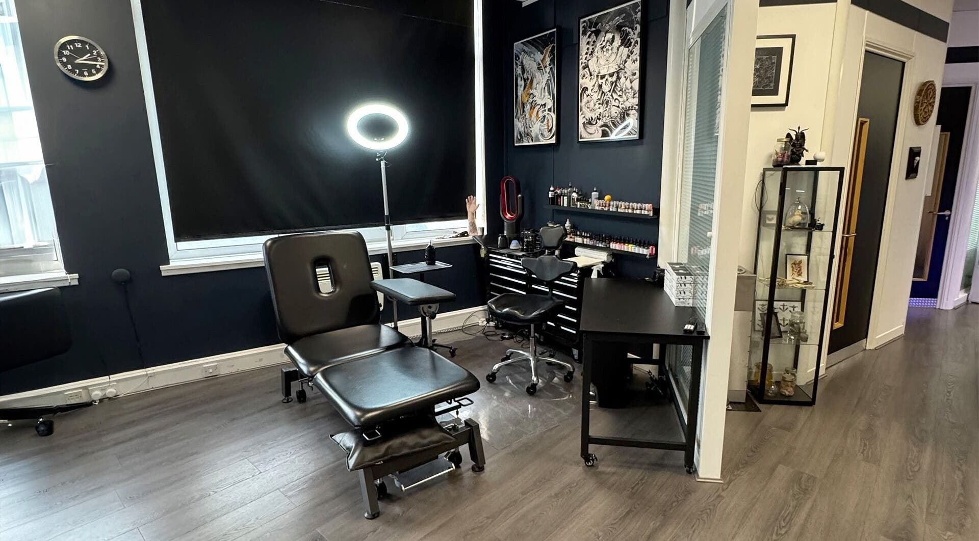 Creative interior of Valhalla Tattoo Studio, Kilmarnock, Scotland, GB featuring tattoo workstations and art.