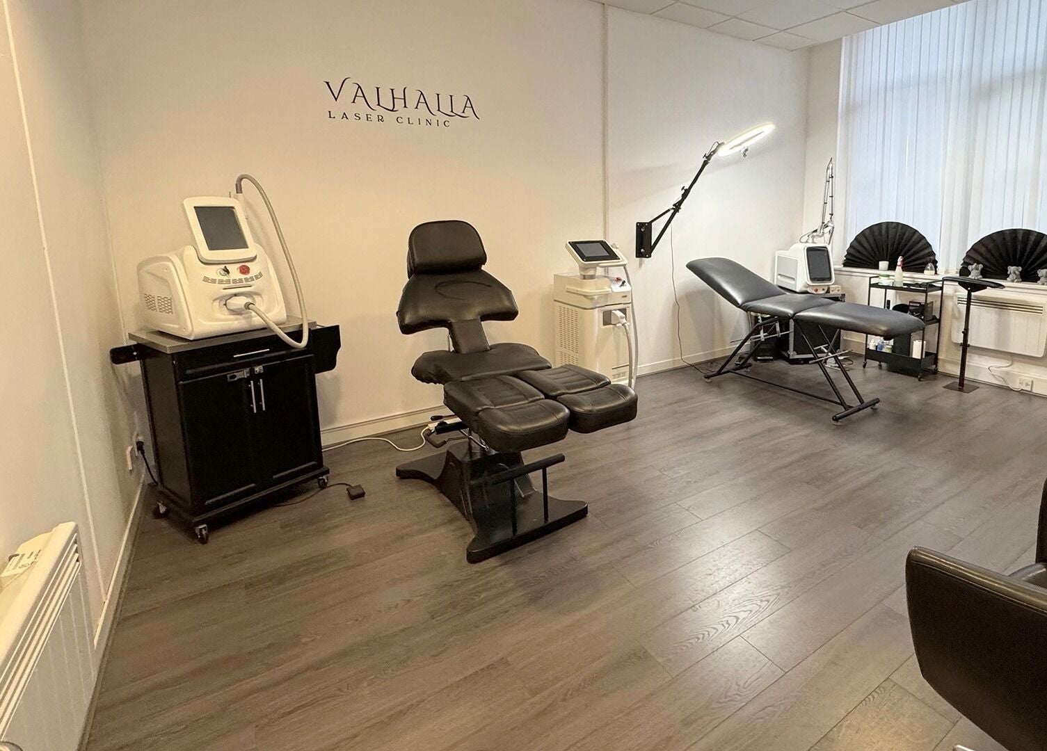 Modern interior of Valhalla Tattoo Studio in Kilmarnock, Scotland, GB, showcasing sleek furniture and equipment.