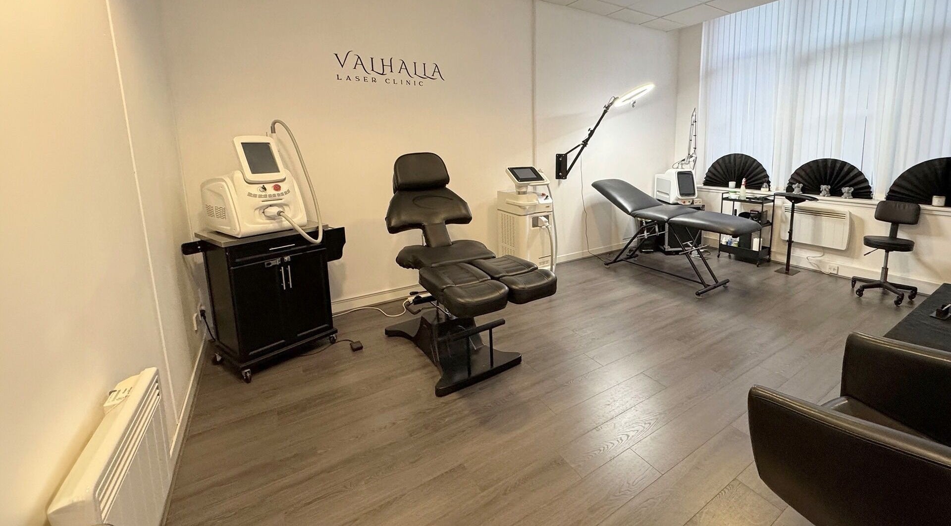 Modern interior of Valhalla Tattoo Studio in Kilmarnock, Scotland, GB, showcasing sleek furniture and equipment.