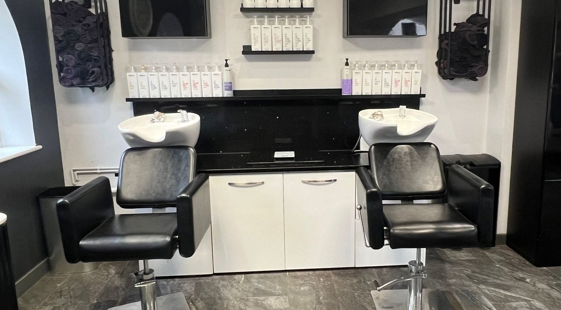Modern salon chairs and wash basins at The Infirmary Hair & Beauty, Stafford, Staffordshire, England, GB.