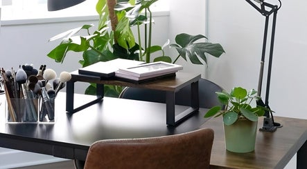Elegant beauty workspace at EDDA Studio, Chipping Norton, England, GB with makeup brushes and greenery.