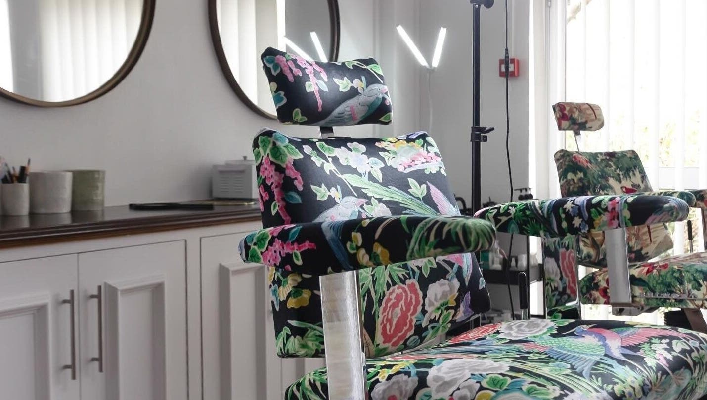 Floral-patterned salon chair at Atelier Yurga in Chipping Norton, England, GB, designed for comfort and style.