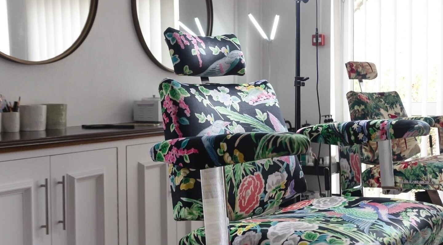 Floral-patterned salon chair at Atelier Yurga in Chipping Norton, England, GB, designed for comfort and style.