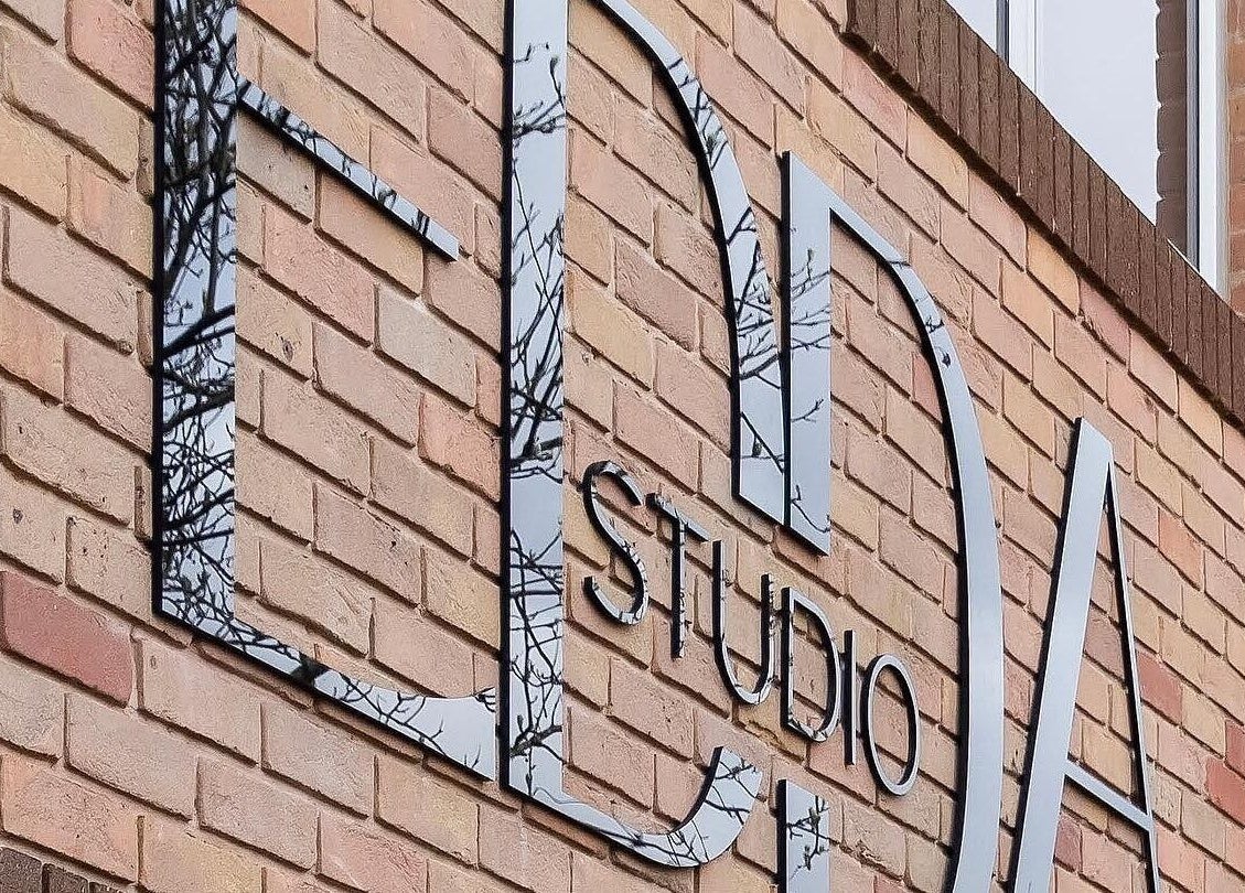 Reflective sign on Atelier Yurga's brick wall at Chipping Norton, England, GB.