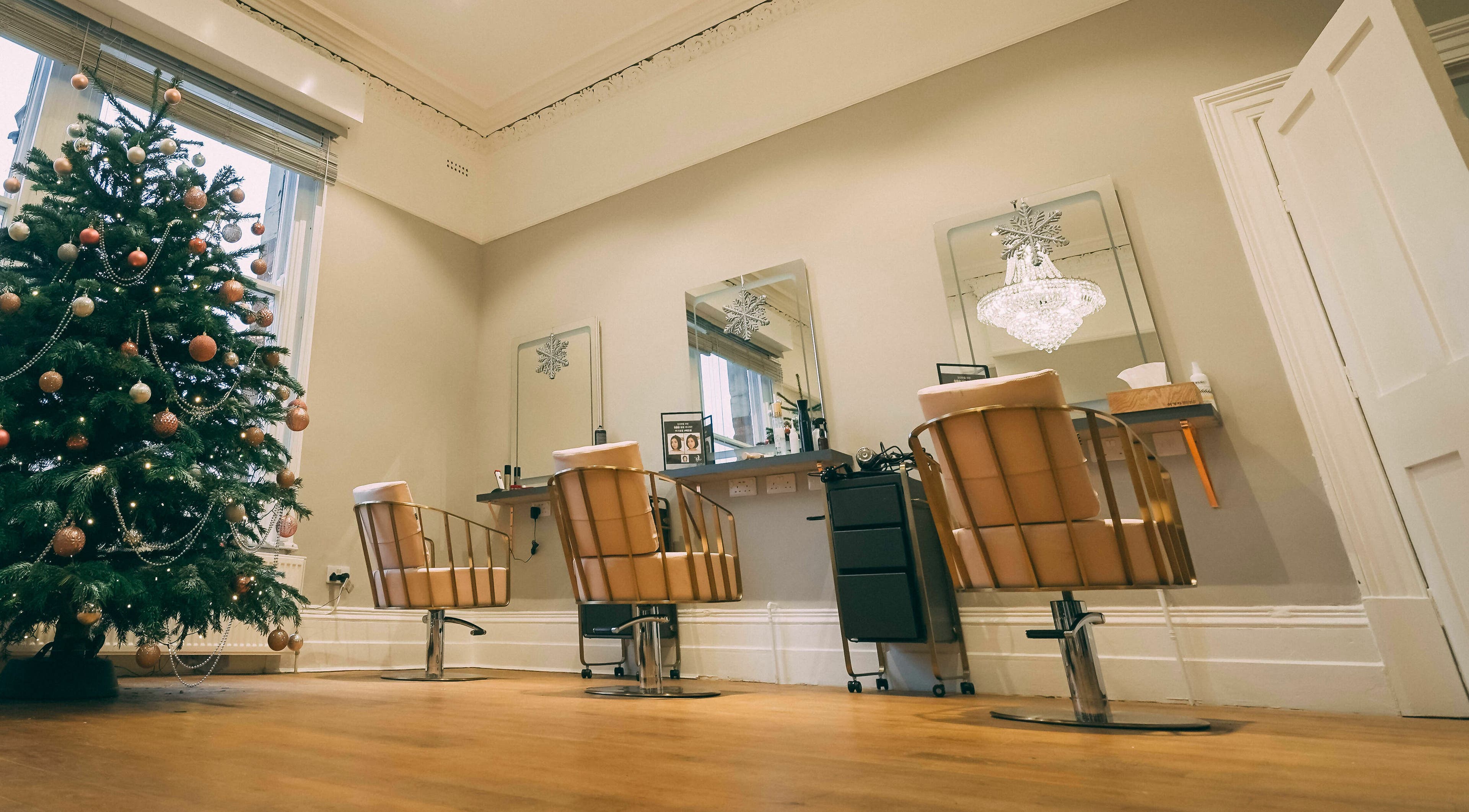 Leekaja Hair and Beauty in Leeds, England, GB, featuring festive decor and modern salon chairs beside a Christmas tree.
