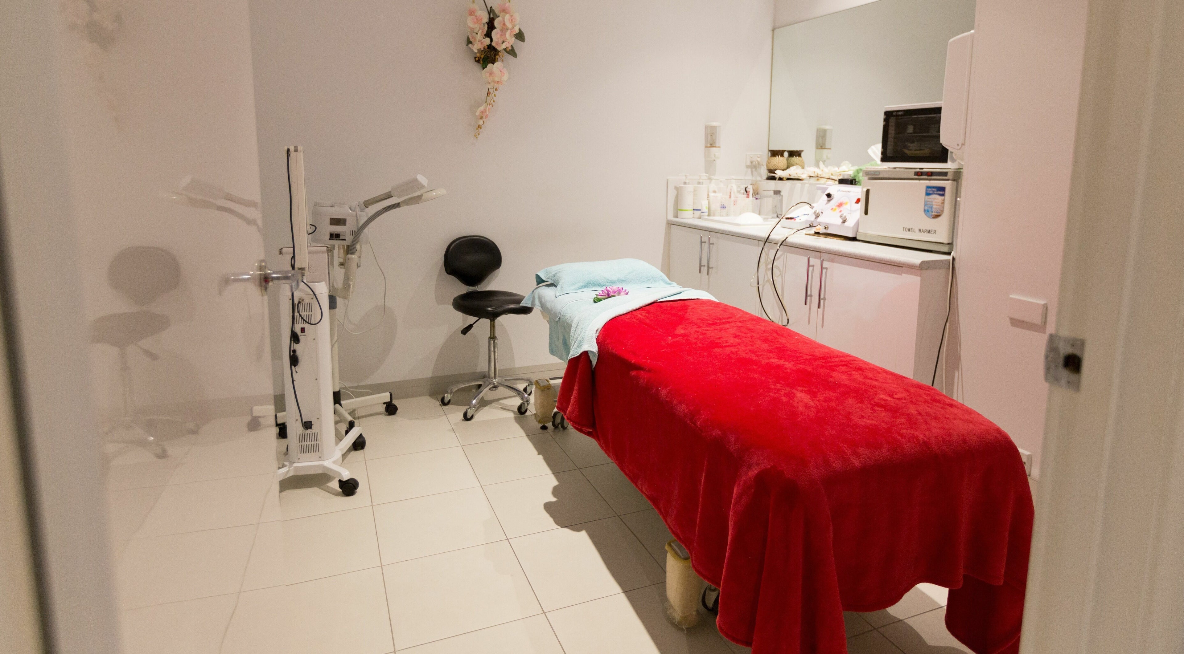 A cozy treatment room at Beauty 4 Life Altona in Melbourne, Victoria, AU with a red covered table.