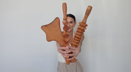Therapist showing wooden massage tools at AMORE BODY LAB, Applecross, Western Australia, AU.
