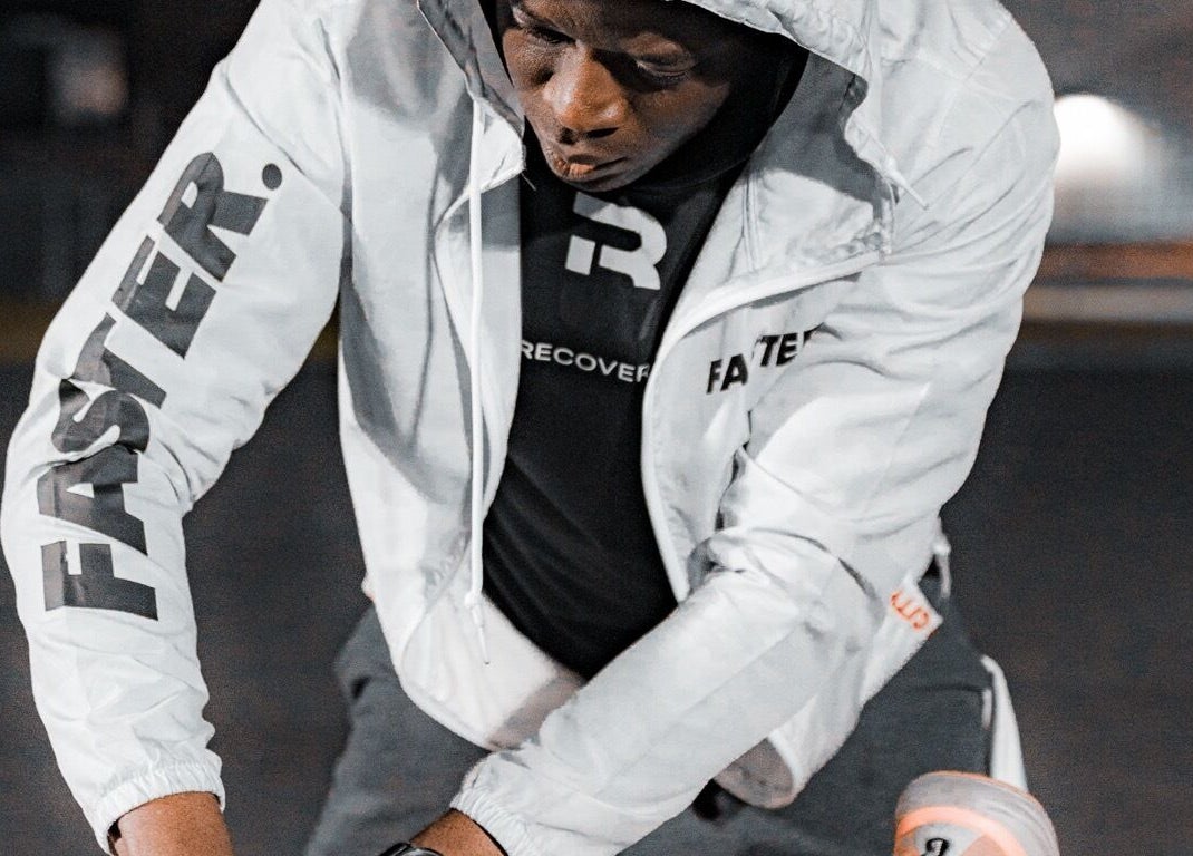 Focused athlete training outdoors in branded gear at Recover U Online (TeleHealth) in Houston, Texas, US.