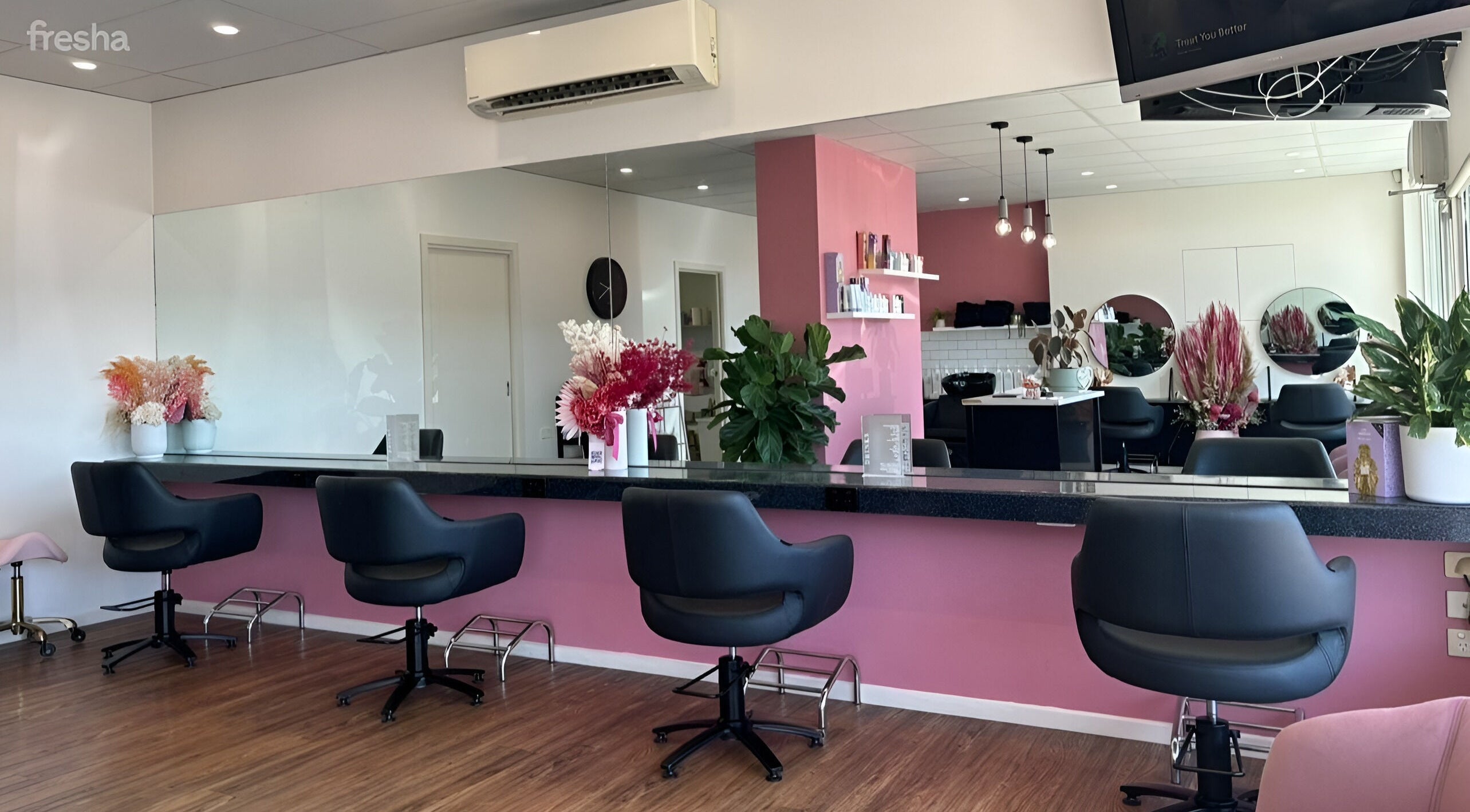Interior of The Rosy Blonde, a stylish salon in Melbourne, Victoria, AU, with modern chairs and pink accents.
