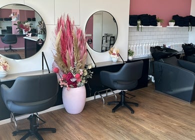 Interior of The Rosy Blonde salon in Melbourne, Victoria, AU with chic chairs and large mirrors.