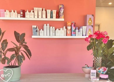 The Rosy Blonde salon interior with pink walls, product shelves, flowers in Melbourne, Victoria, AU.