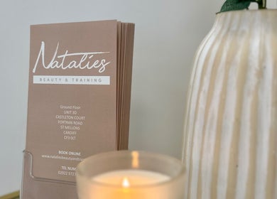 Natalies Beauty & Training brochure and candle in Cardiff, Wales, GB create a calming ambiance.