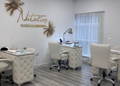 Chic nail stations at Natalies Beauty & Training in Cardiff, Wales, GB, featuring plush white chairs and stylish decor.