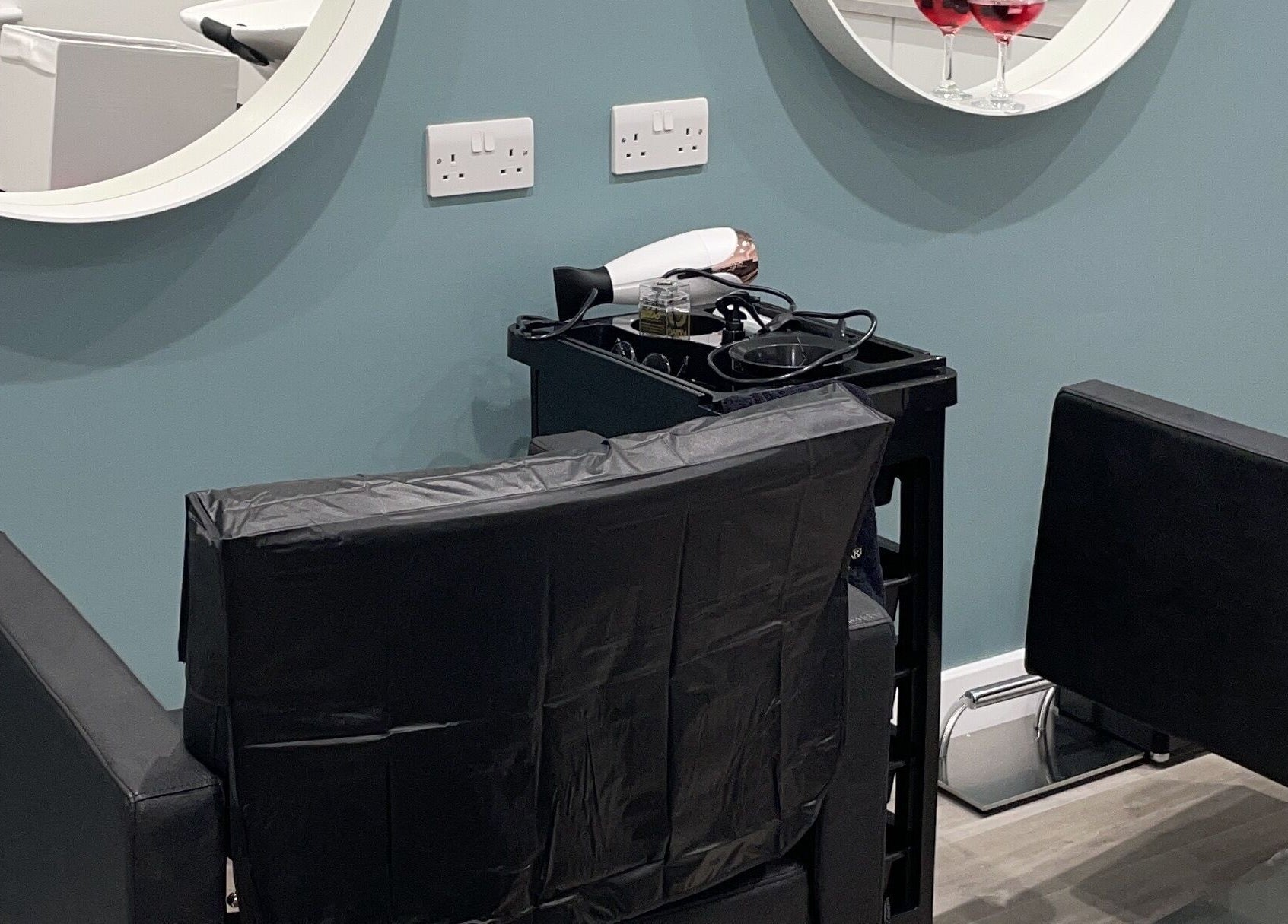 Salon station at Tresses Colour & Styling Room in Rochford, England, featuring sleek chairs and mirrors.
