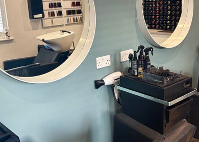 Stylish salon setup at Tresses Colour & Styling Room, Rochford, England, GB with mirrors and hair products.