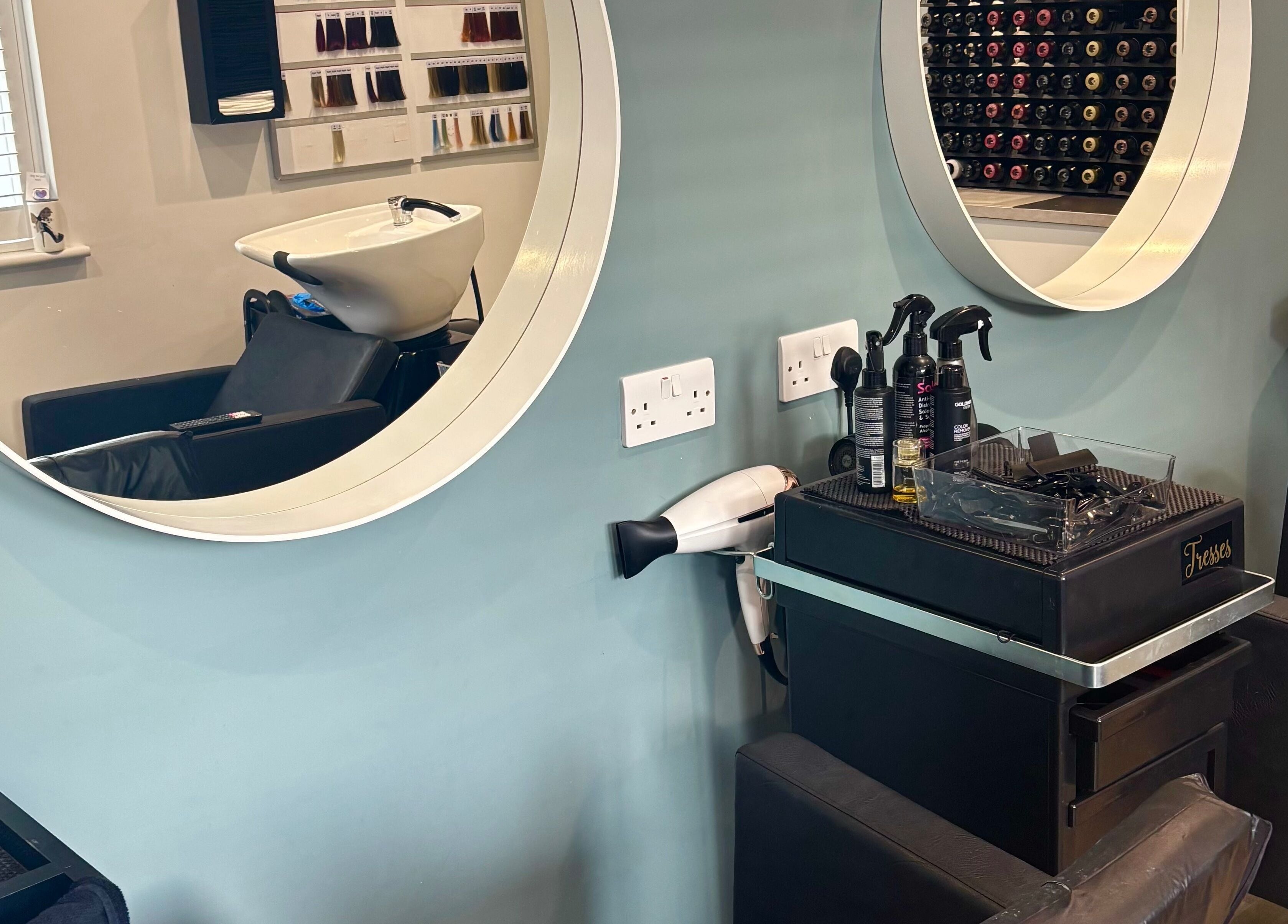 Stylish salon setup at Tresses Colour & Styling Room, Rochford, England, GB with mirrors and hair products.