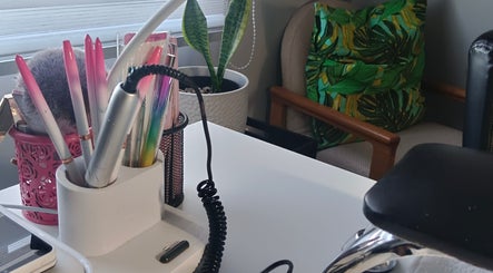 Scarletgold Beauty Salon in Gauteng, ZA features a stylish work desk with beauty tools and plant decor.