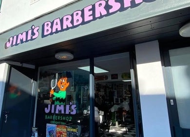 Entrance of Queer Shears at Jimi’s Barbershop, Brighton, England, showcasing vibrant signage.
