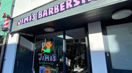 Entrance of Queer Shears at Jimi’s Barbershop, Brighton, England, showcasing vibrant signage.