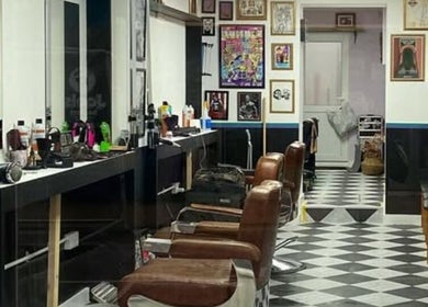 Stylish interior of Queer Shears at Jimi’s Barbershop in Brighton, England, showcasing barber chairs and decor.