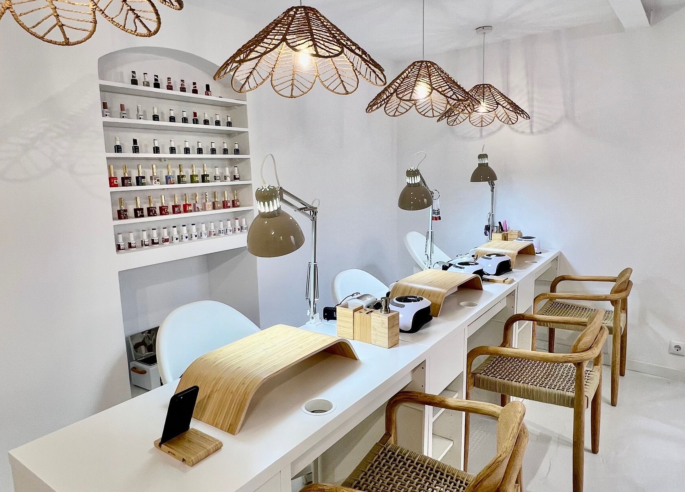 Bright nail salon interior at Bless Nails Lisbon, Lisboa, Lisboa, PT with manicure stations and polish display.