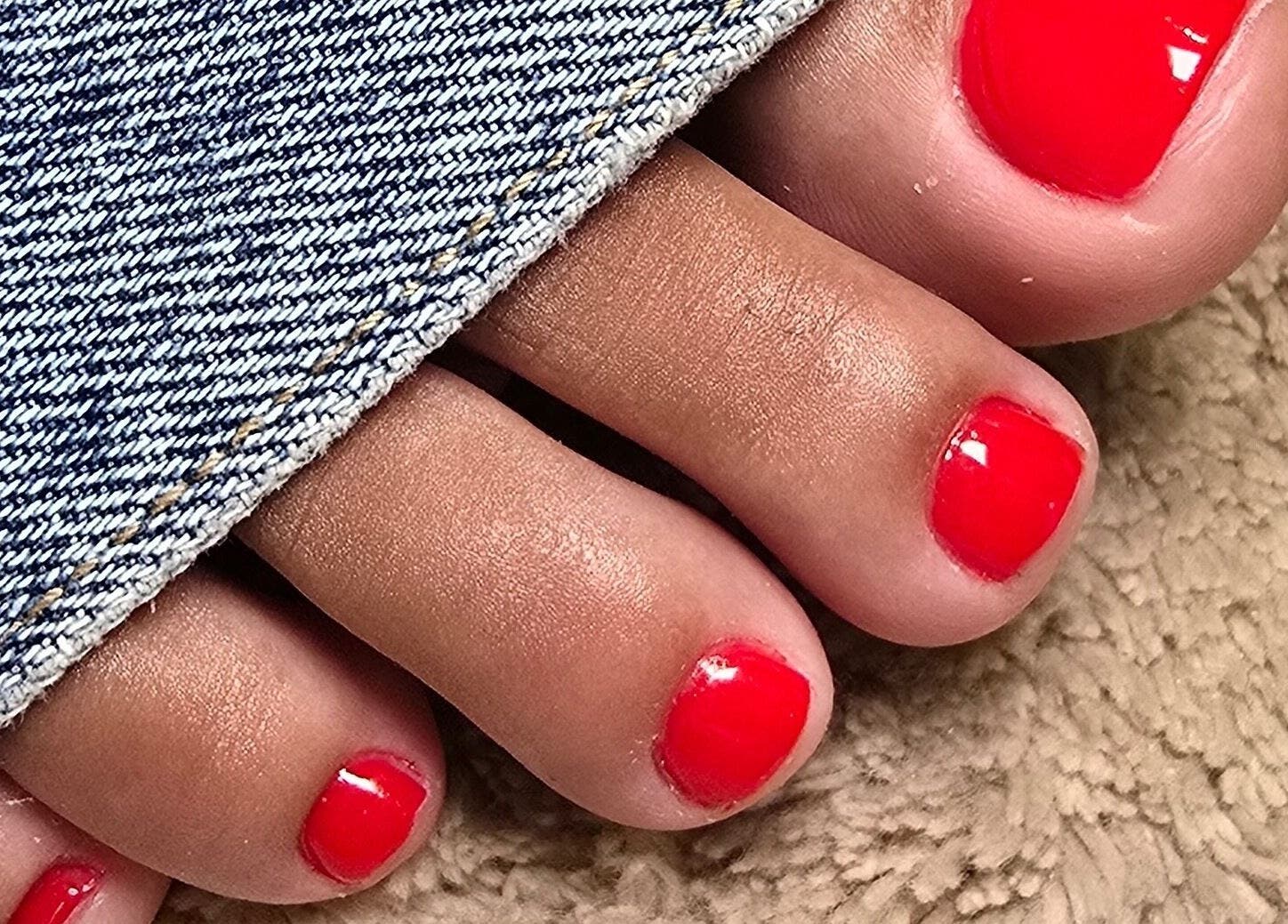 Close-up of bright red toenails at Bless Nails Lisbon, Lisboa, Lisboa, PT, showcasing a stylish pedicure.