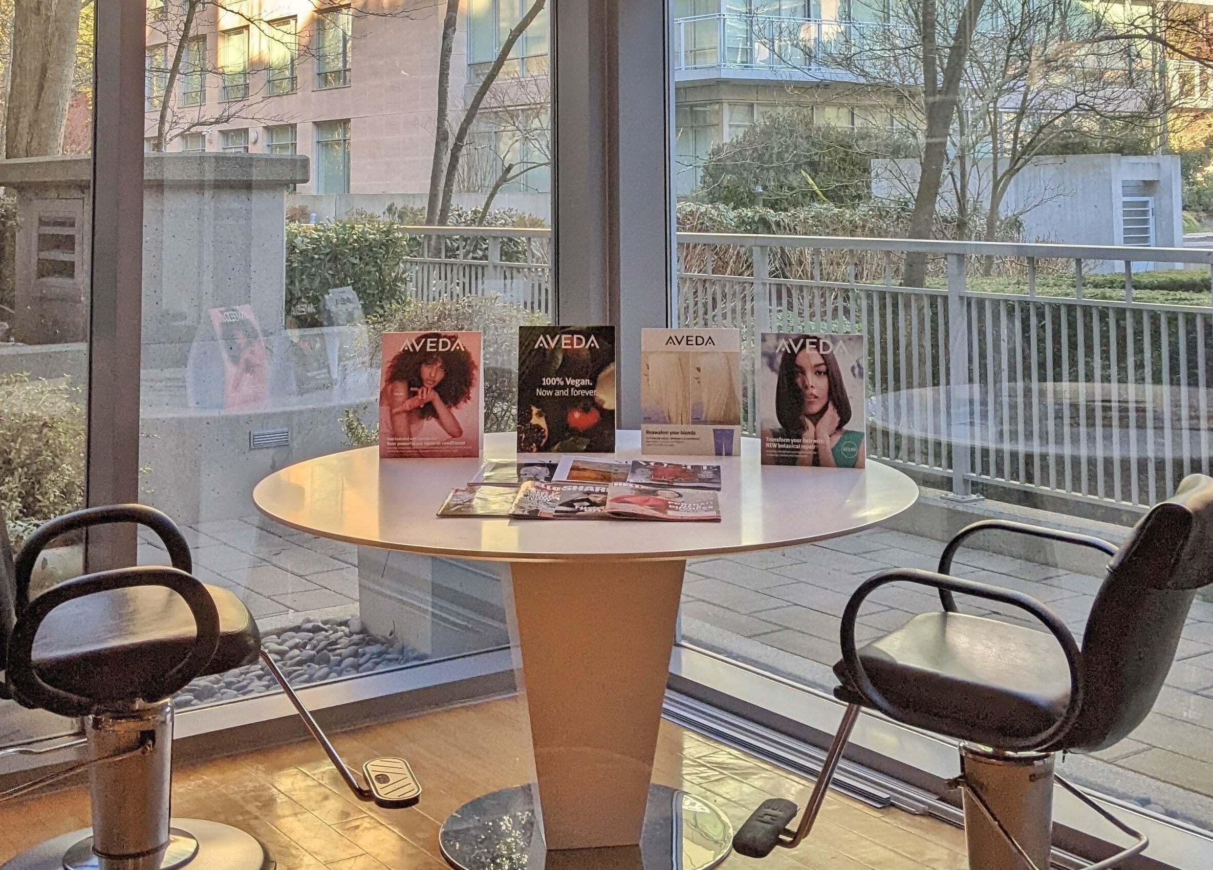 Sunny seating area with salon chairs at E2 Salon Ubc in Vancouver, British Columbia, CA with Aveda products displayed.