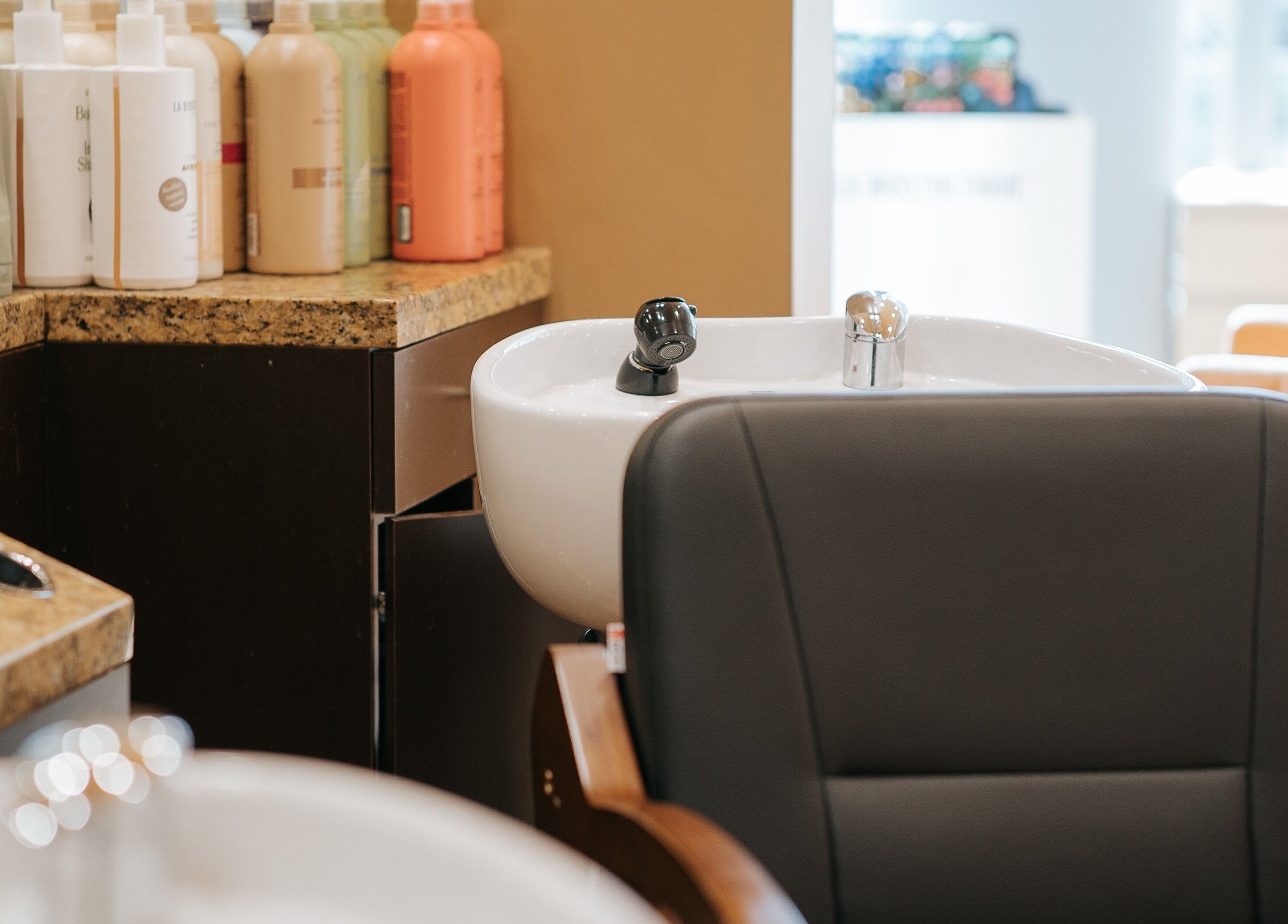 E2 Salon Ubc in Vancouver, British Columbia, CA, featuring a sleek salon wash station with product display.