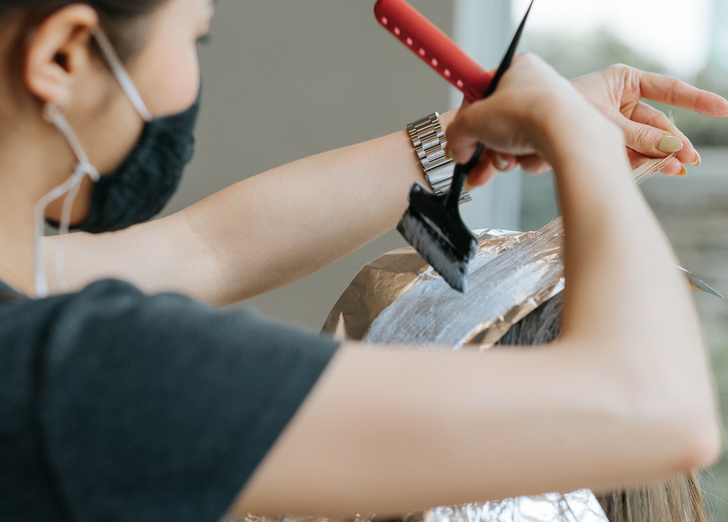 Stylist applying hair color at E2 Salon Ubc, Vancouver, British Columbia, CA.